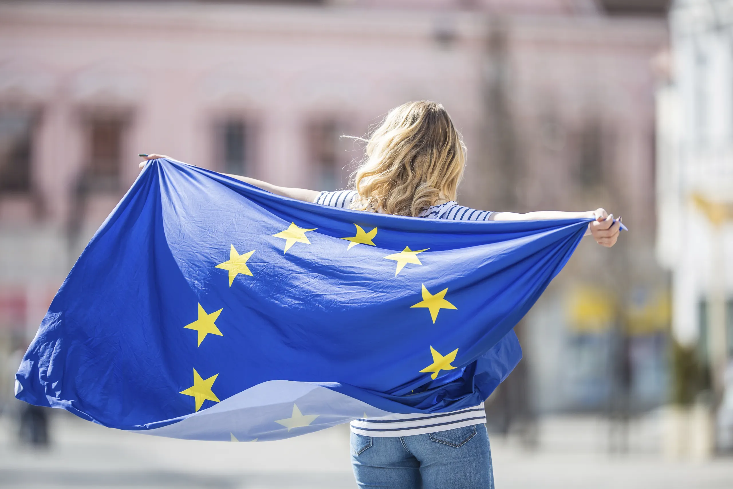 Eine Frau weht mit einer großen Europafahne
